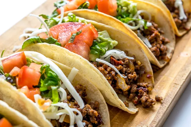 Three beef tacos with cilantro and lime