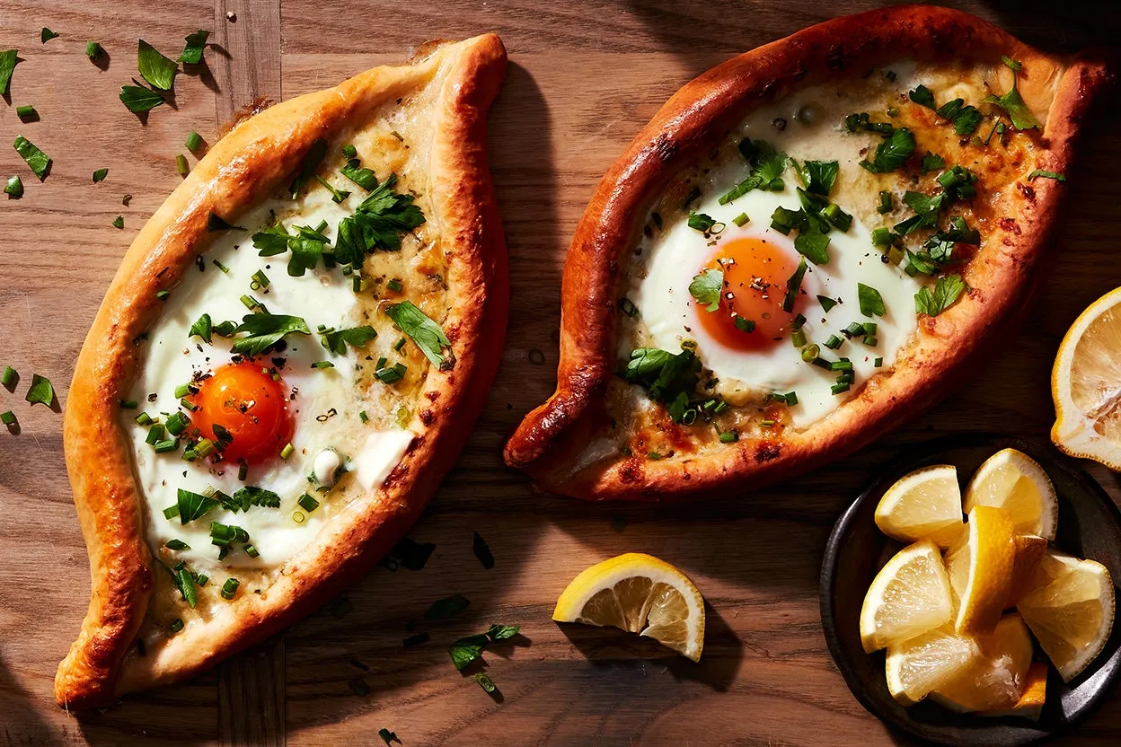 Boat-shaped bread filled with melted cheese and an egg yolk