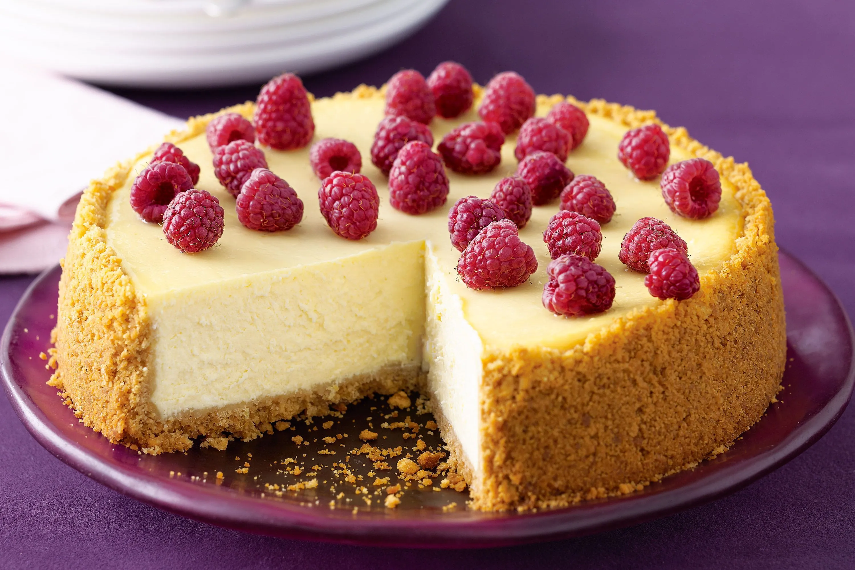 A slice of thick New York cheesecake with strawberry sauce