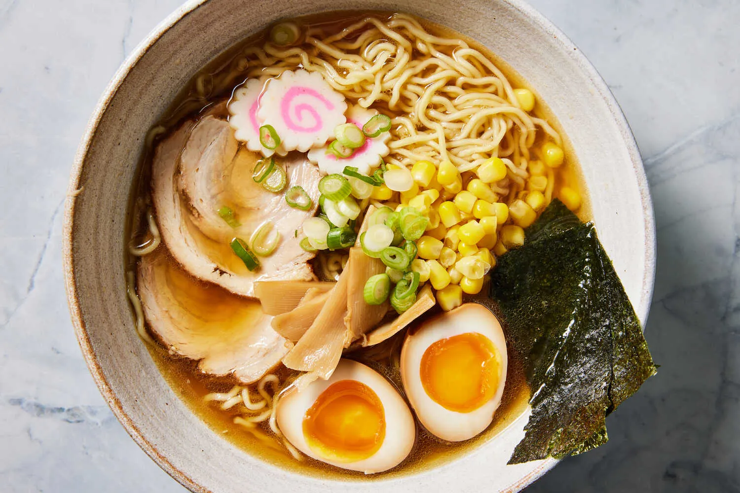 A steaming bowl of shoyu ramen with soft-boiled egg