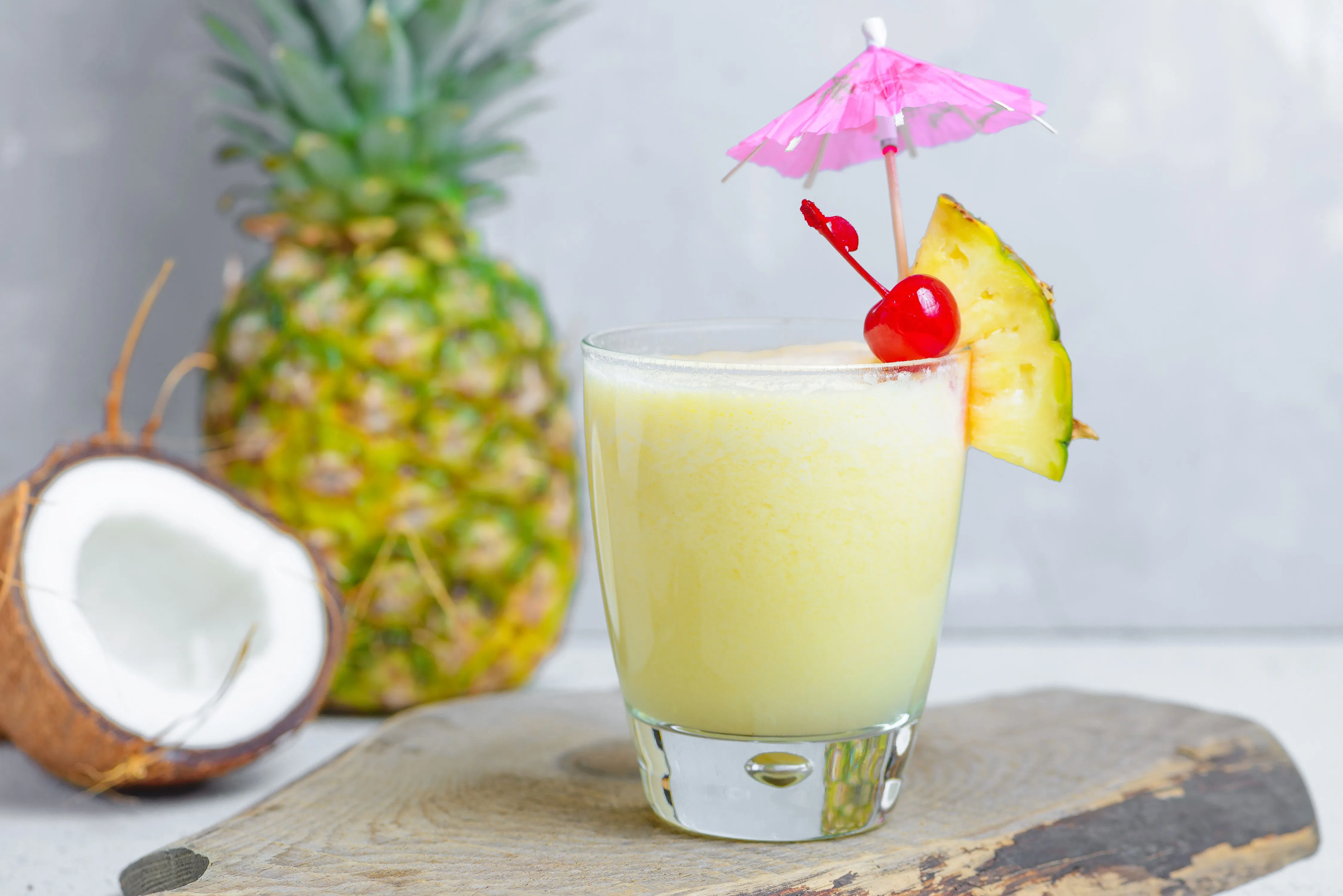 A tall glass of Virgin Colada with a pineapple wedge and cherry